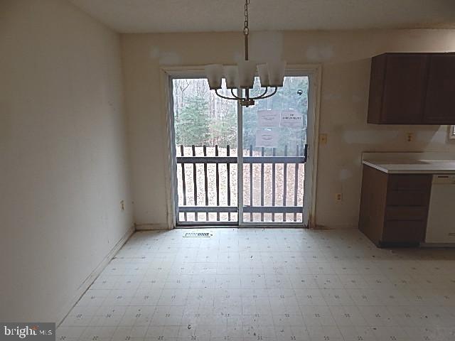 unfurnished dining area with a notable chandelier