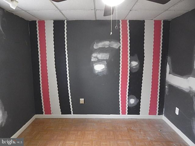 spare room with parquet floors and a paneled ceiling