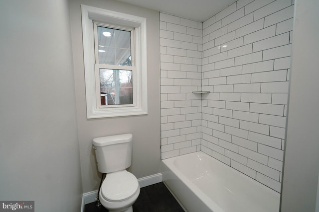 bathroom featuring tiled shower / bath and toilet