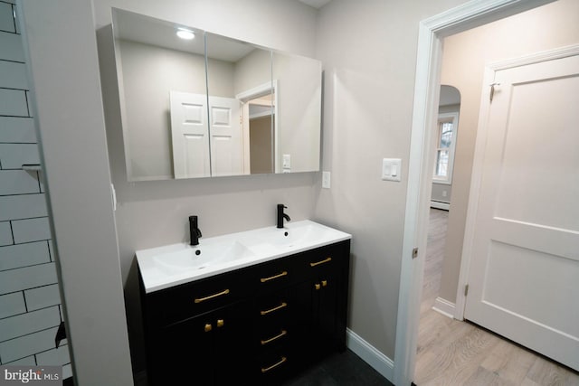 bathroom with hardwood / wood-style flooring, vanity, and a baseboard radiator