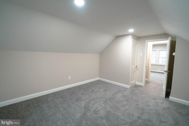 additional living space featuring a baseboard radiator, lofted ceiling, and carpet floors