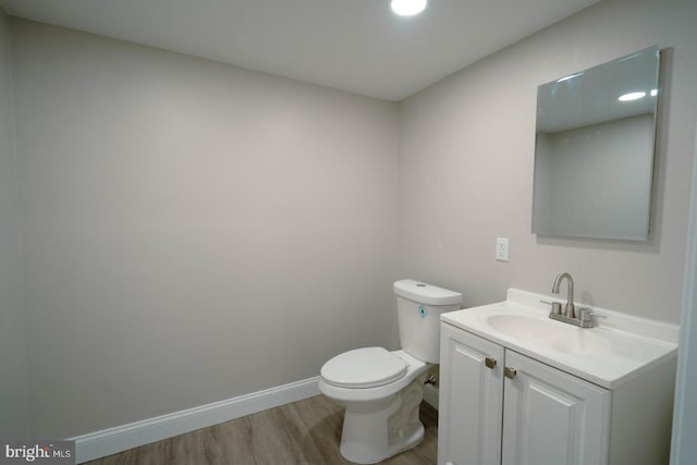 bathroom featuring wood-type flooring, vanity, and toilet