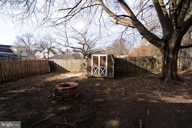 view of yard featuring a storage shed and an outdoor fire pit