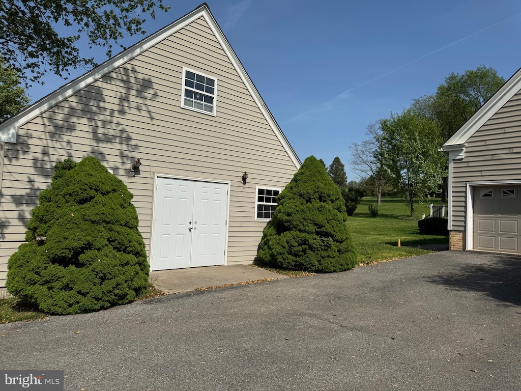 view of side of home with a garage and aphalt driveway