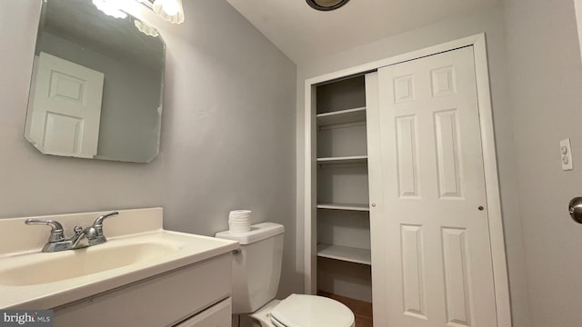 bathroom featuring vanity, vaulted ceiling, and toilet