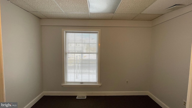 unfurnished room with a drop ceiling