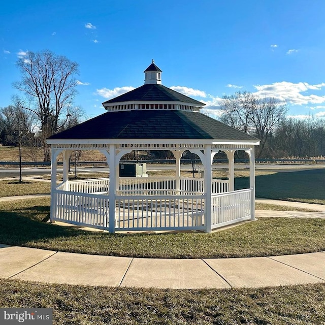 surrounding community with a gazebo, a lawn, and a water view