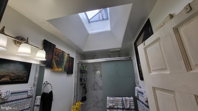 bathroom with a skylight and a shower with door