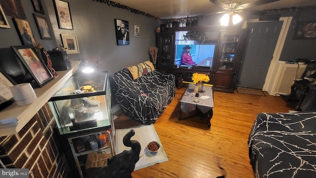 living room featuring wood-type flooring and ceiling fan