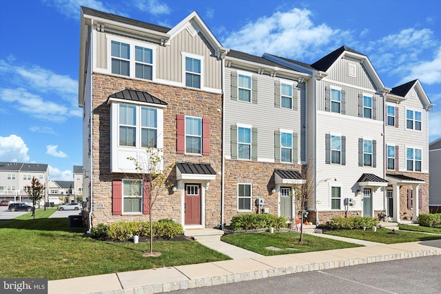 townhome / multi-family property featuring cooling unit and a front yard