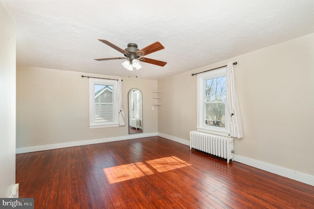 unfurnished room with ceiling fan, radiator heating unit, dark hardwood / wood-style floors, and a textured ceiling