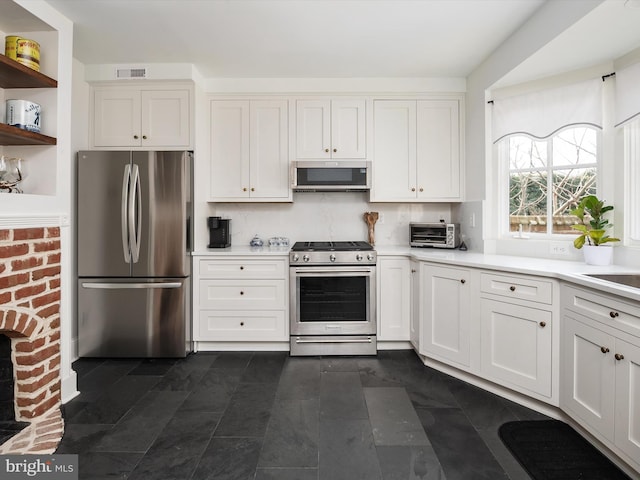 143 Market St, Annapolis, MD 21401 - kitchen with white cabinetry, backsplash, and stainless steel appliances