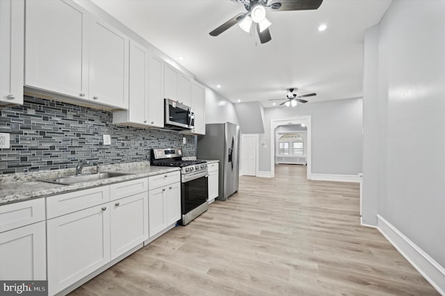 kitchen featuring light stone counters, sink, white cabinets, and appliances with stainless steel finishes