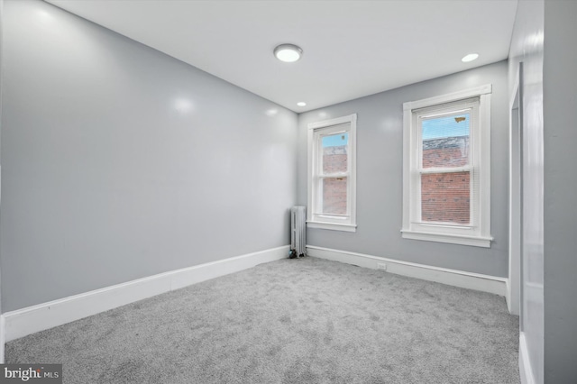 empty room with carpet flooring and radiator