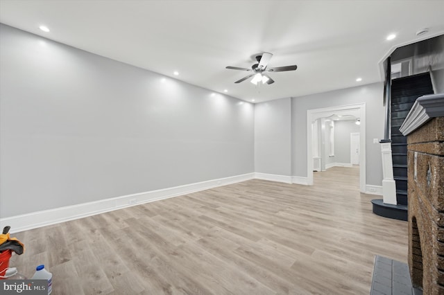 unfurnished living room featuring ceiling fan and light wood-type flooring