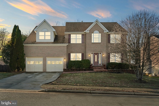 colonial home with a yard and a garage