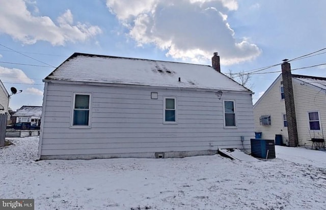 snow covered rear of property with cooling unit