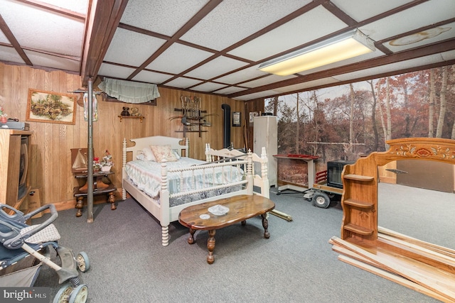 carpeted bedroom featuring wood walls