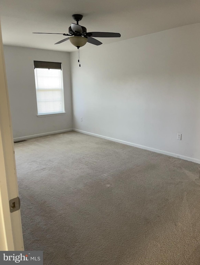 spare room with light colored carpet and ceiling fan