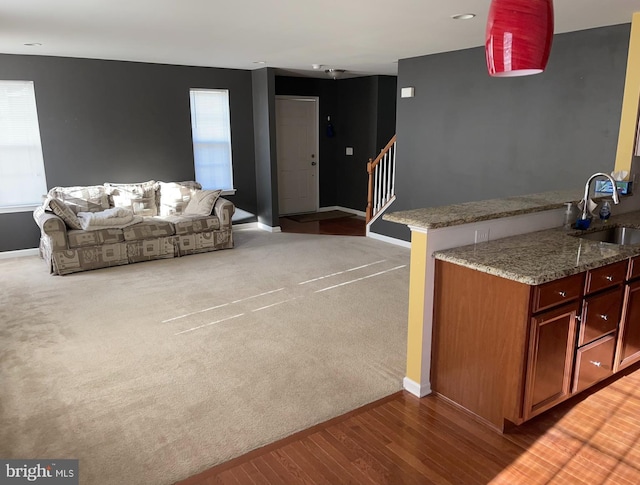 interior space with light stone countertops, sink, and light carpet