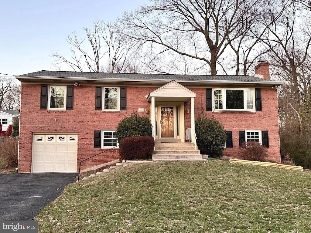 split foyer home with a front yard and a garage