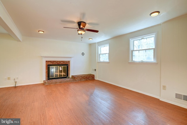 unfurnished living room featuring a fireplace, ceiling fan, and light hardwood / wood-style floors