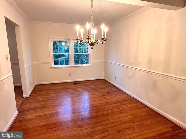 spare room with hardwood / wood-style floors, a chandelier, and ornamental molding