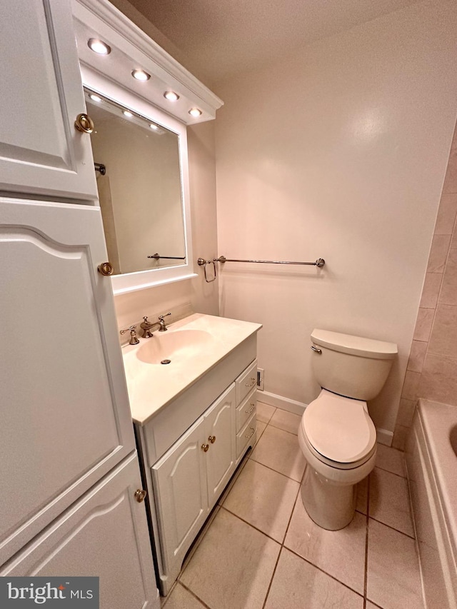 bathroom with vanity, a washtub, toilet, and tile patterned floors