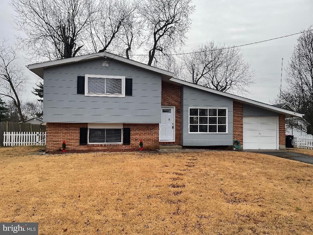 split level home with a garage and a front lawn