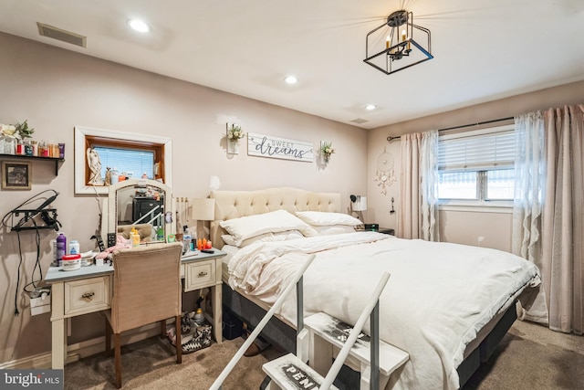 carpeted bedroom with an inviting chandelier