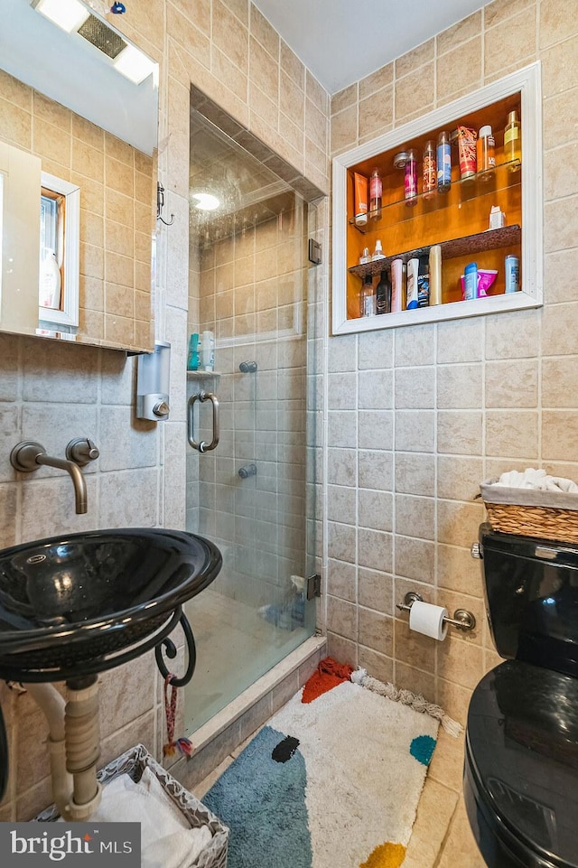 bathroom with sink, tile walls, and a shower with shower door