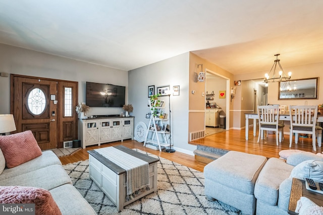 living room with an inviting chandelier and light hardwood / wood-style floors