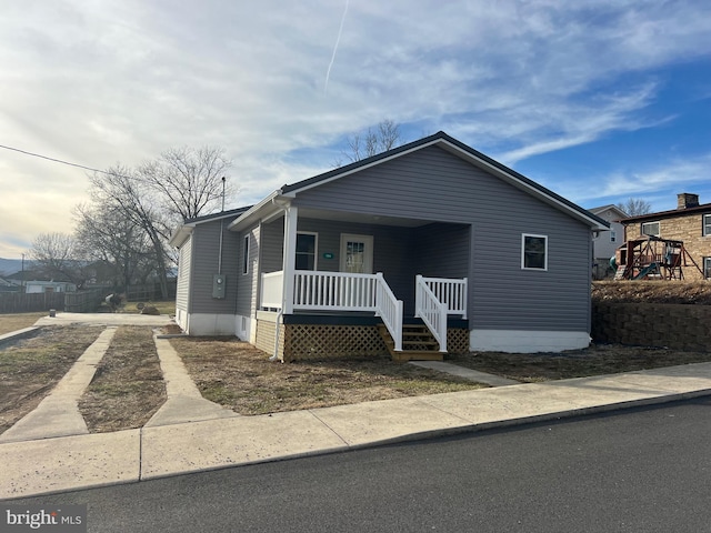 view of front of property with a playground and covered porch