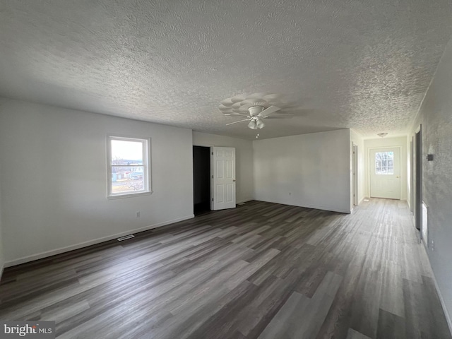 spare room featuring a textured ceiling, dark hardwood / wood-style floors, and ceiling fan