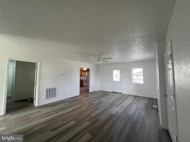 unfurnished living room featuring ceiling fan, dark hardwood / wood-style floors, and a textured ceiling