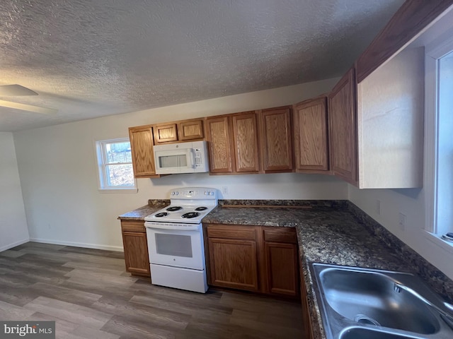 kitchen featuring sink, white appliances, a textured ceiling, ceiling fan, and hardwood / wood-style floors