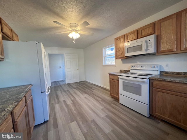 kitchen with ceiling fan, a textured ceiling, white appliances, and light hardwood / wood-style flooring