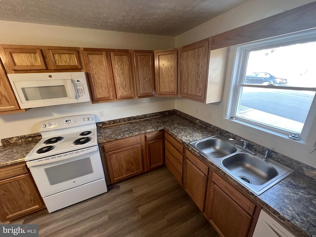 kitchen with sink, white appliances, dark hardwood / wood-style floors, and a textured ceiling