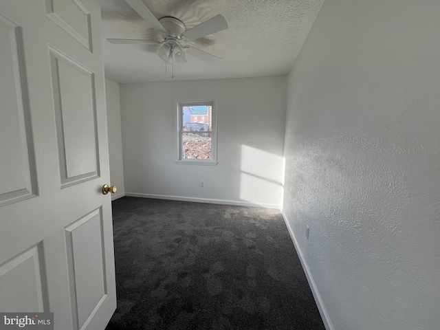 carpeted spare room featuring ceiling fan and a textured ceiling