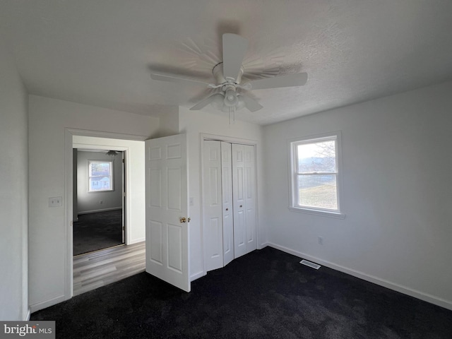 unfurnished bedroom with ceiling fan, a closet, carpet, and a textured ceiling