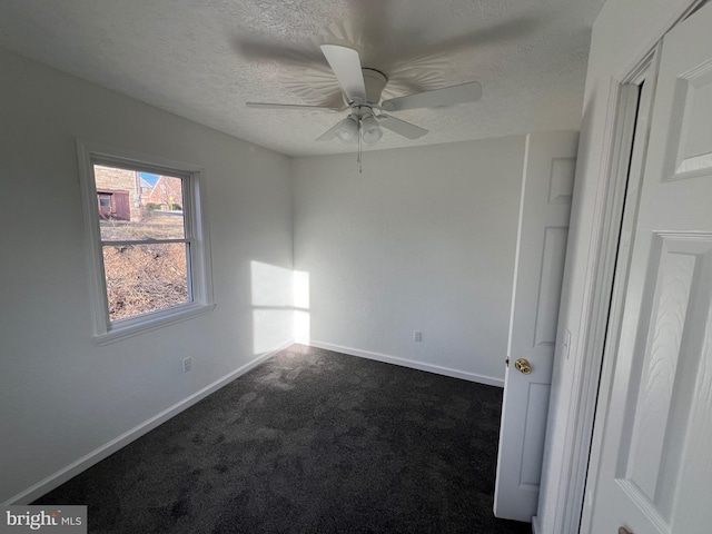 carpeted spare room featuring ceiling fan and a textured ceiling