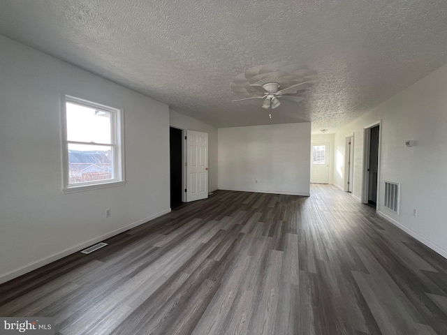 unfurnished room with ceiling fan, dark hardwood / wood-style flooring, and a textured ceiling