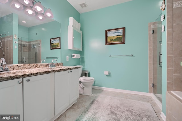 bathroom featuring tile patterned flooring, vanity, toilet, and walk in shower