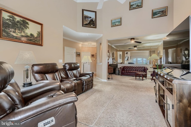 interior space with a towering ceiling, ornamental molding, and ceiling fan