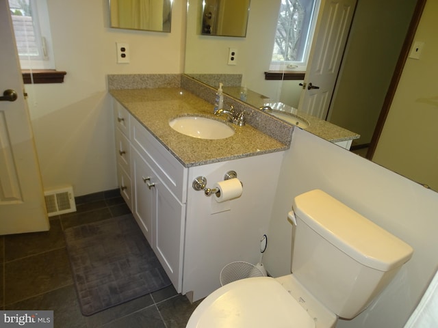 bathroom featuring vanity, tile patterned floors, and toilet