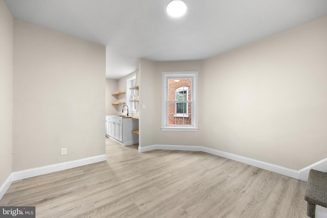 unfurnished living room featuring sink and light wood-type flooring