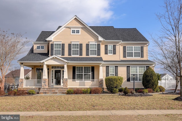 view of front of house with a front yard and covered porch