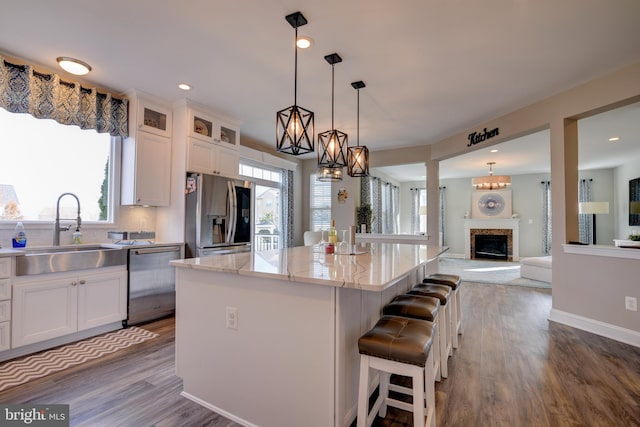 kitchen with white cabinetry, appliances with stainless steel finishes, a center island, and sink