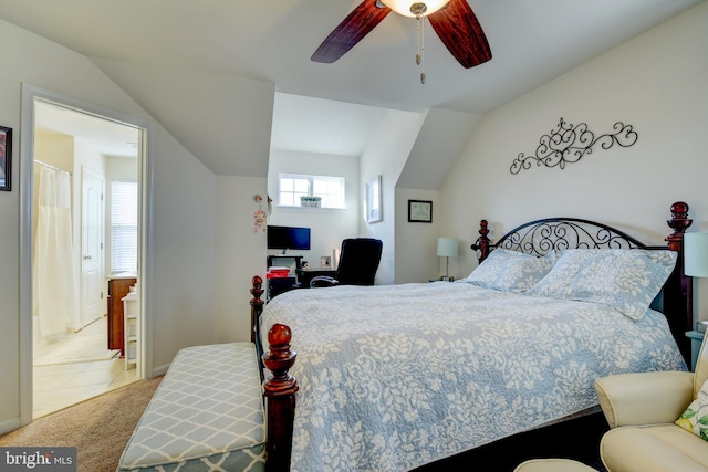 carpeted bedroom featuring ensuite bath, vaulted ceiling, and ceiling fan