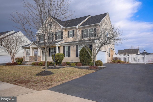 view of front of house featuring a porch, a garage, and a front lawn